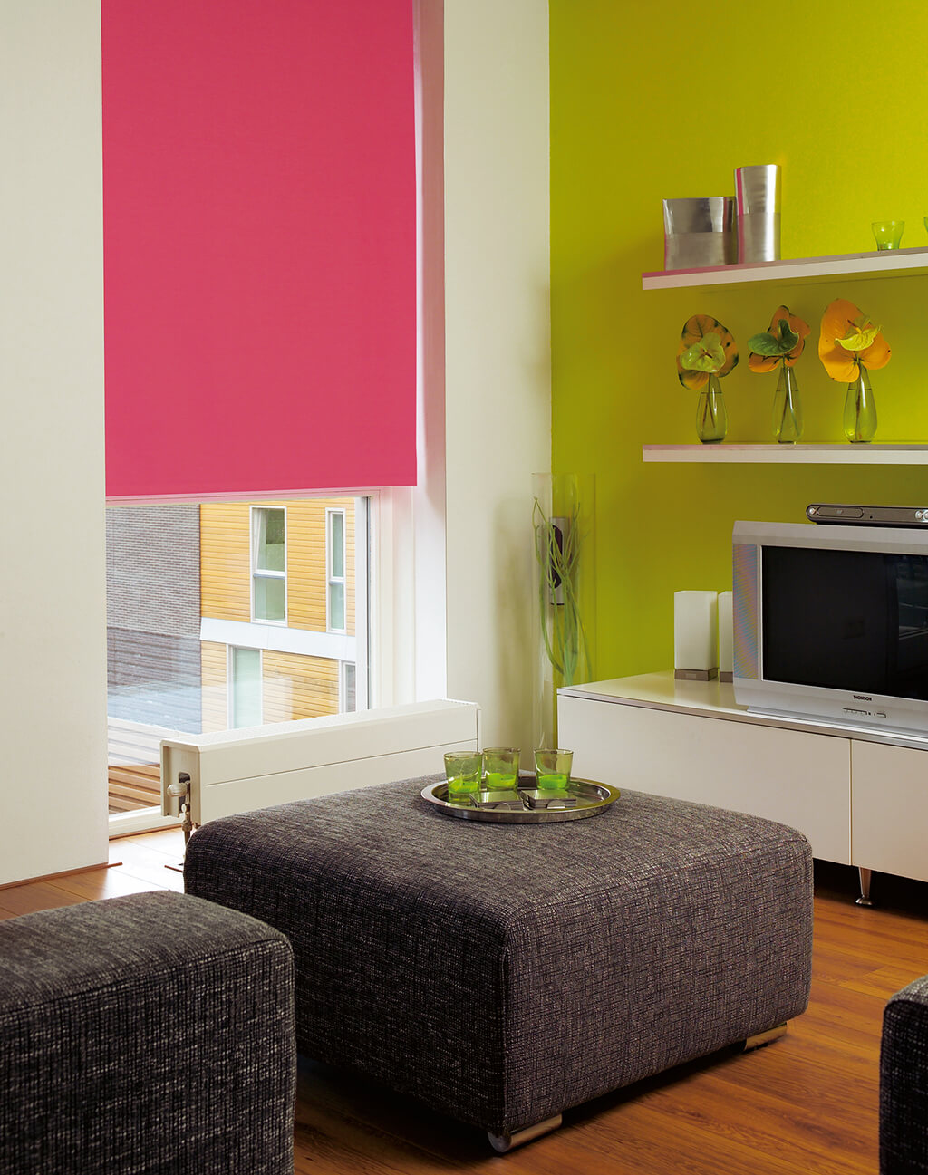 Pinkes Verdunkelungsrollo am deckenhohen Fenster im Wohnzimmer