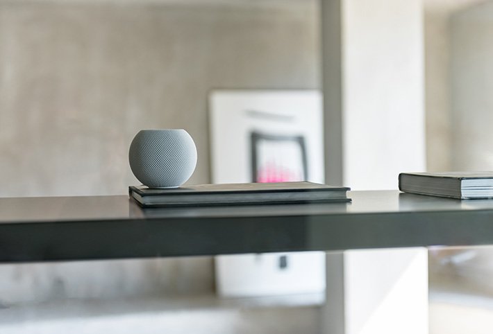 Apple HomePod Mini steht auf einem Tisch.