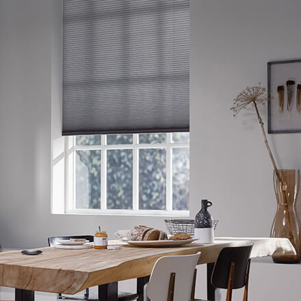 Graues Plisseerollo im Wohnzimmer