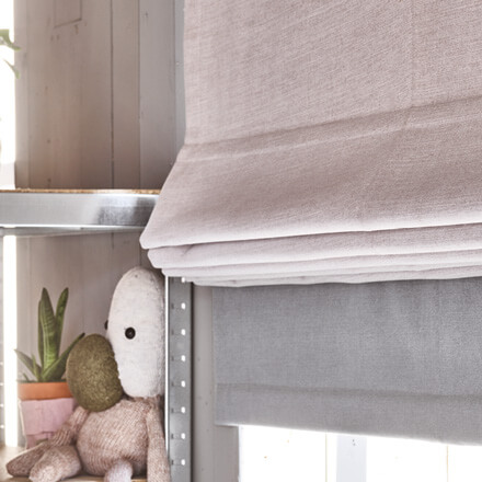 Zweifarbige Raffrollos in rosé und grau im Baby- und Kinderzimmer Zweifarbige Raffrollos in rosé und grau im Baby- und Kinderzimmer