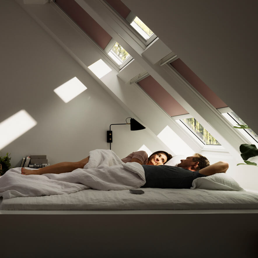 VELUX&reg; Verdunkelungsrollo in einem zarten Beerenton im Schlafzimmer