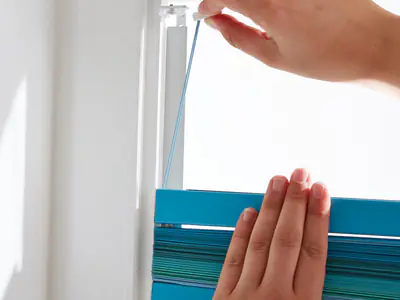 Jalousie wird ohne Bohren mit Klebeleiste am Fensterrahmen befestigt