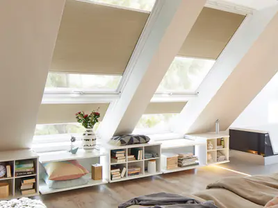 Schlafzimmer unter dem Dach mit beigen Wabenplissees an VELUX-Dachfenstern